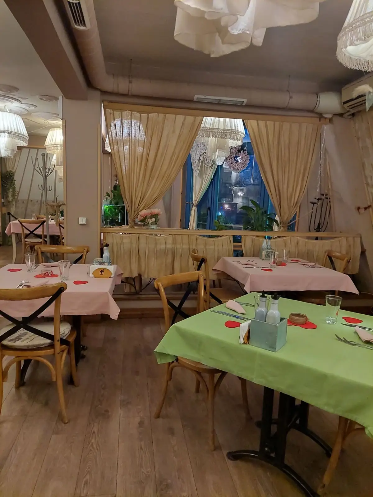 Салонът с бежови завеси и зелени маси